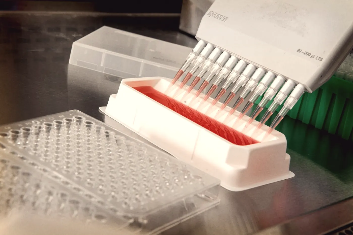 An automated multichannel pipette filling a sample plate in a laboratory, as in lab HIV testing