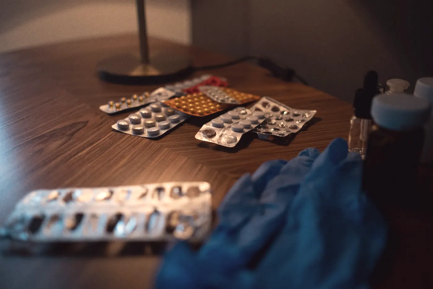 Blister packs of tablets and medical gloves on a table