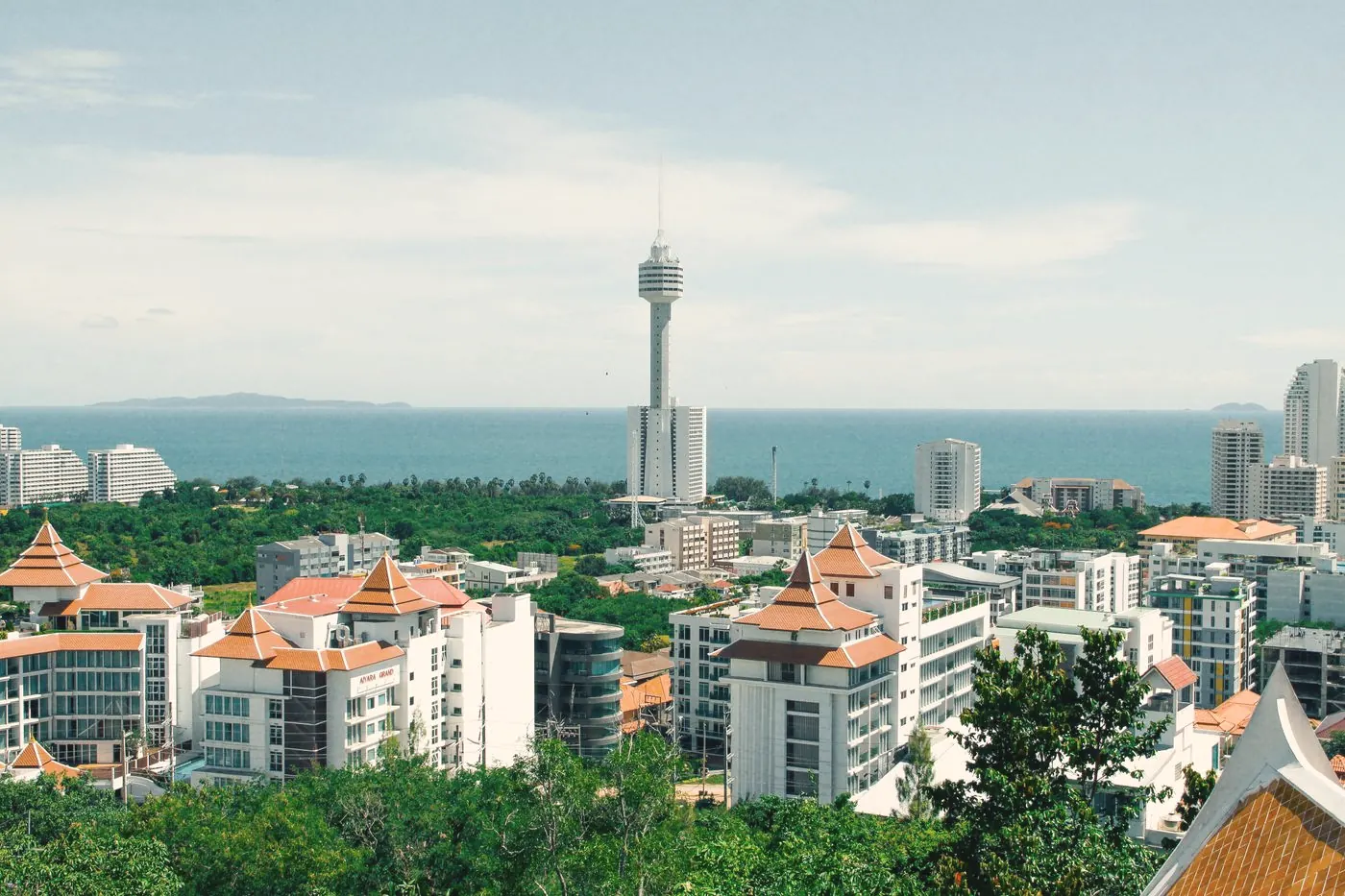 A coastal city in Thailand with a tall tower, hotels and the sea under a clear sky