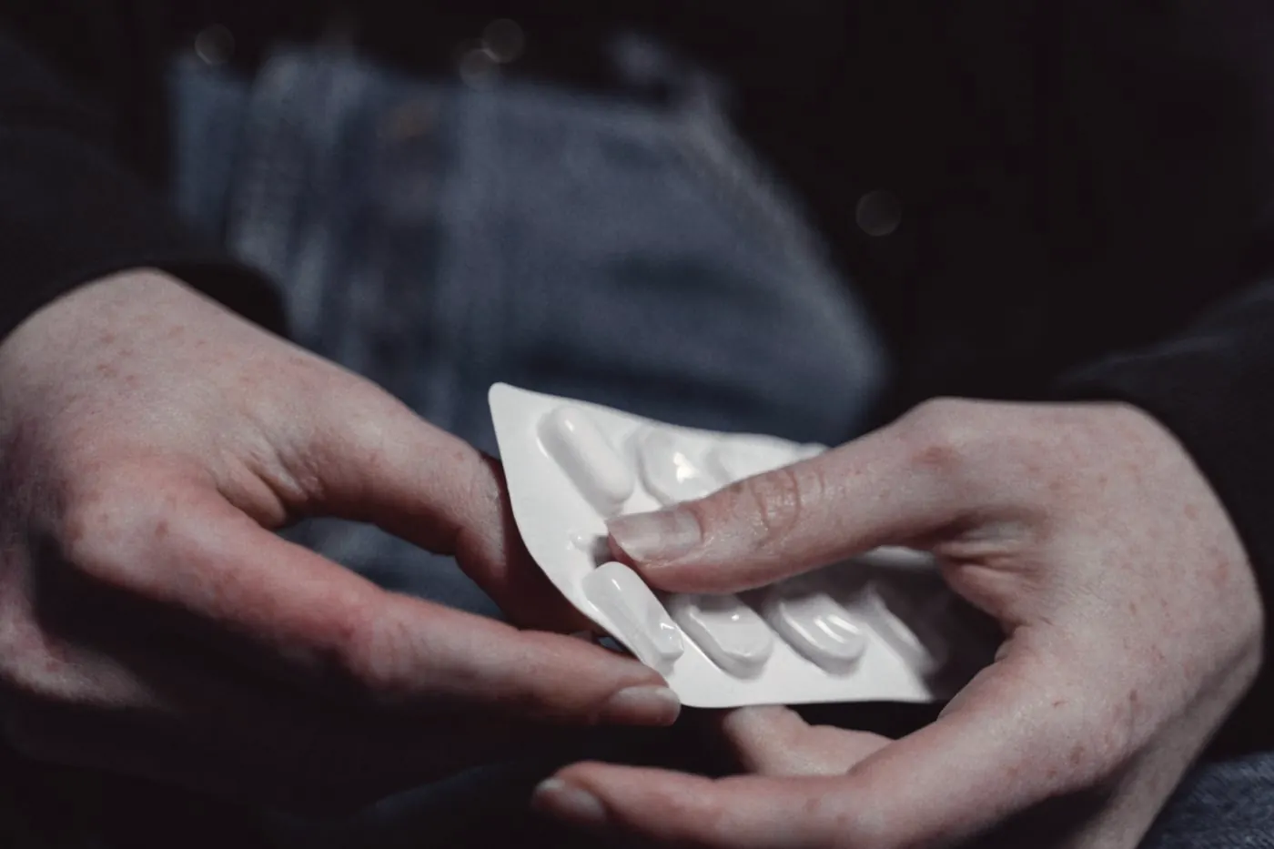Hands holding a blister pack of tablets while checking when the next dose is due