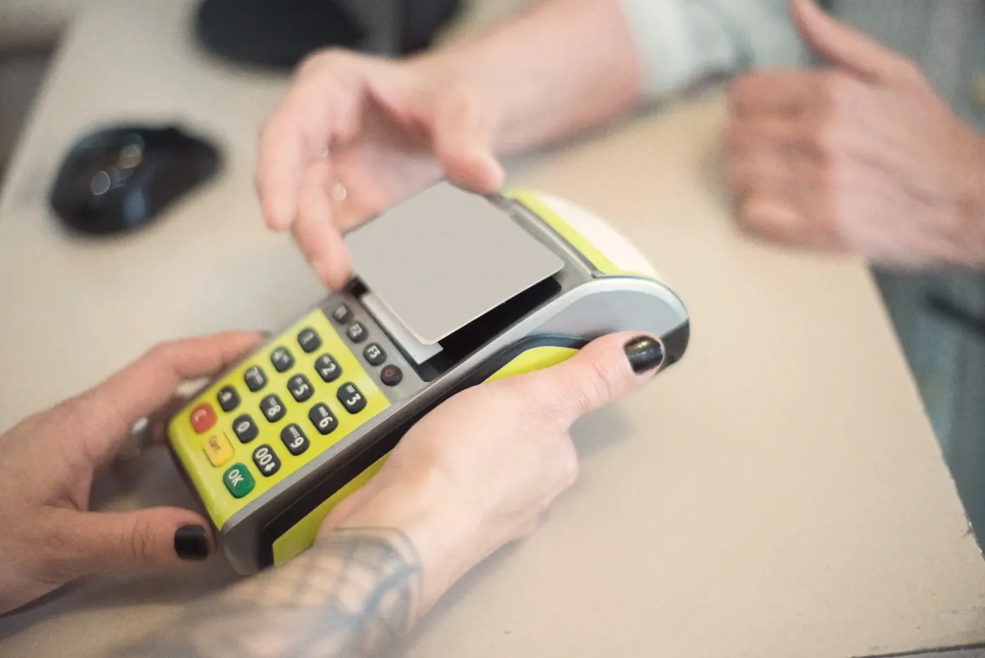 Hands paying for a medical test by card at a payment terminal