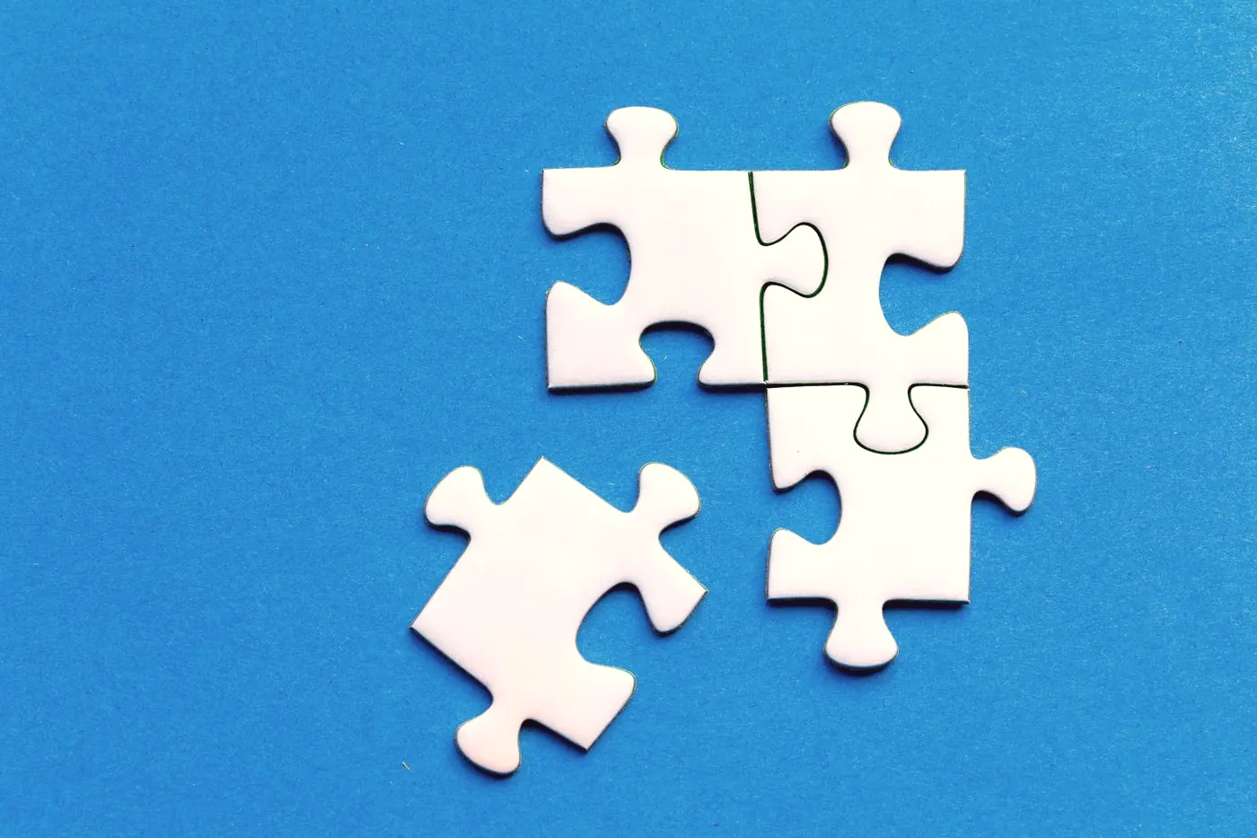 White jigsaw puzzle pieces fitting together on a blue background