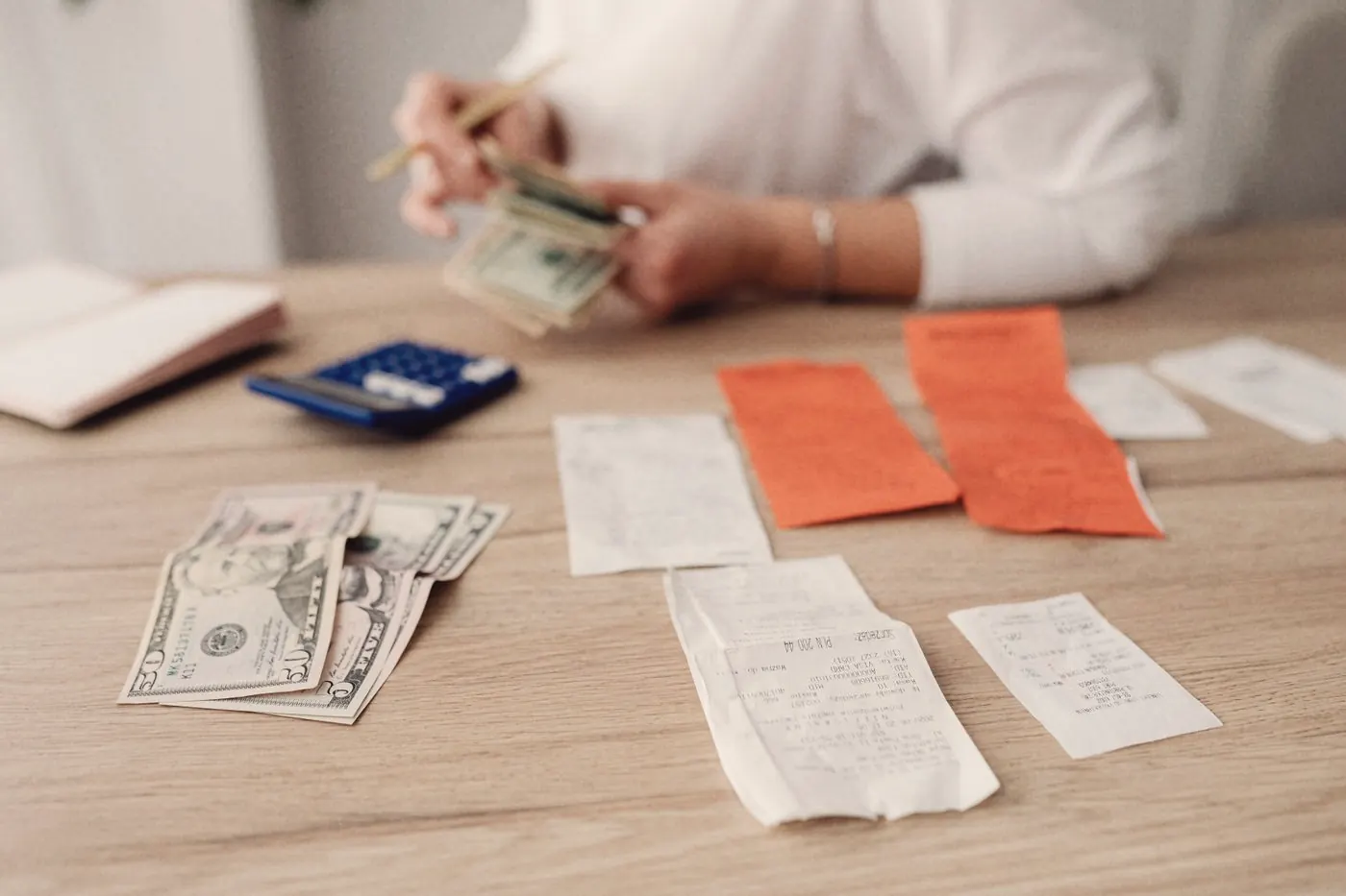A calculator, cash and notes used to plan a medical budget