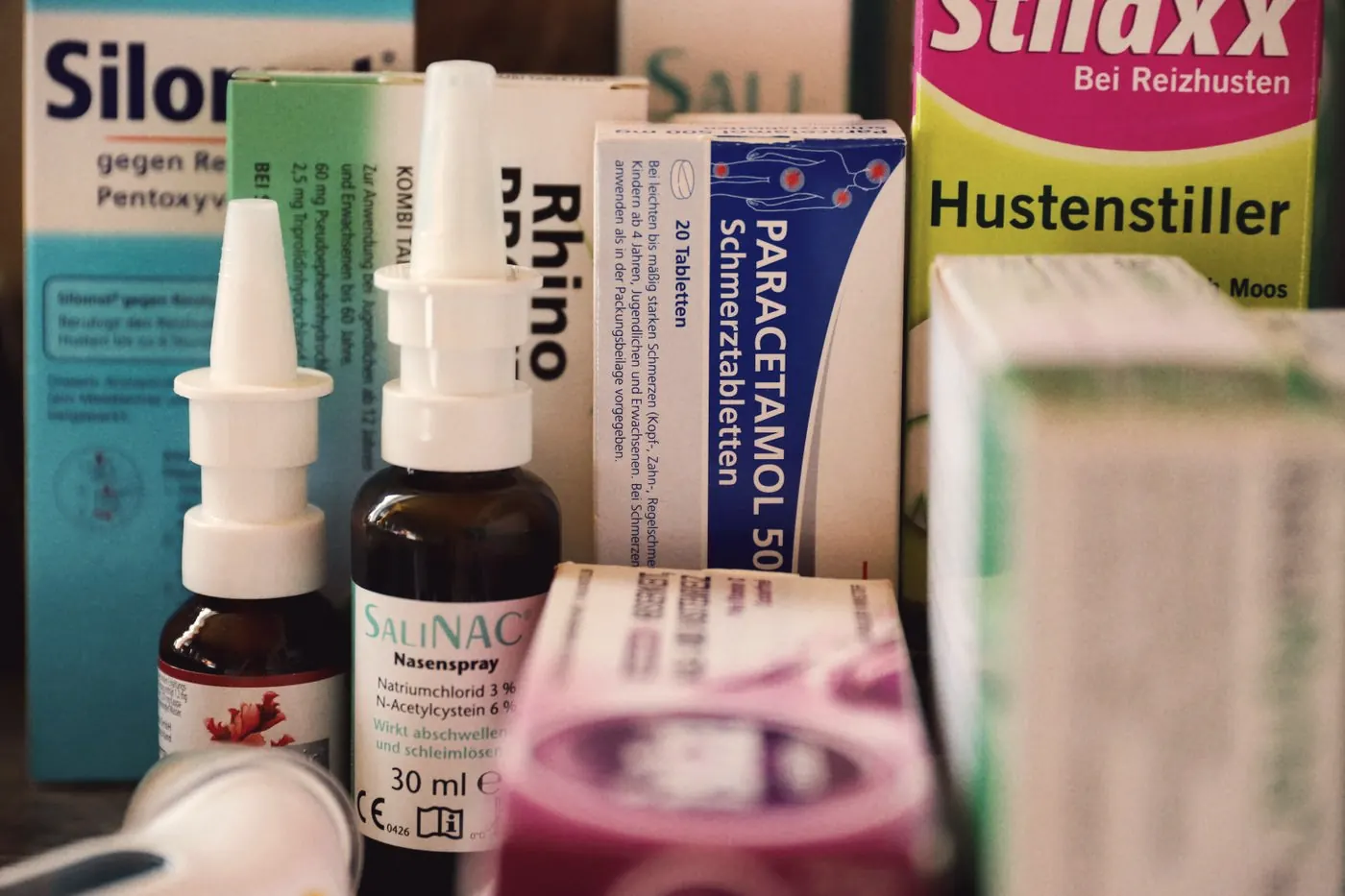 Over-the-counter cold and flu medicines lined up on a pharmacy counter