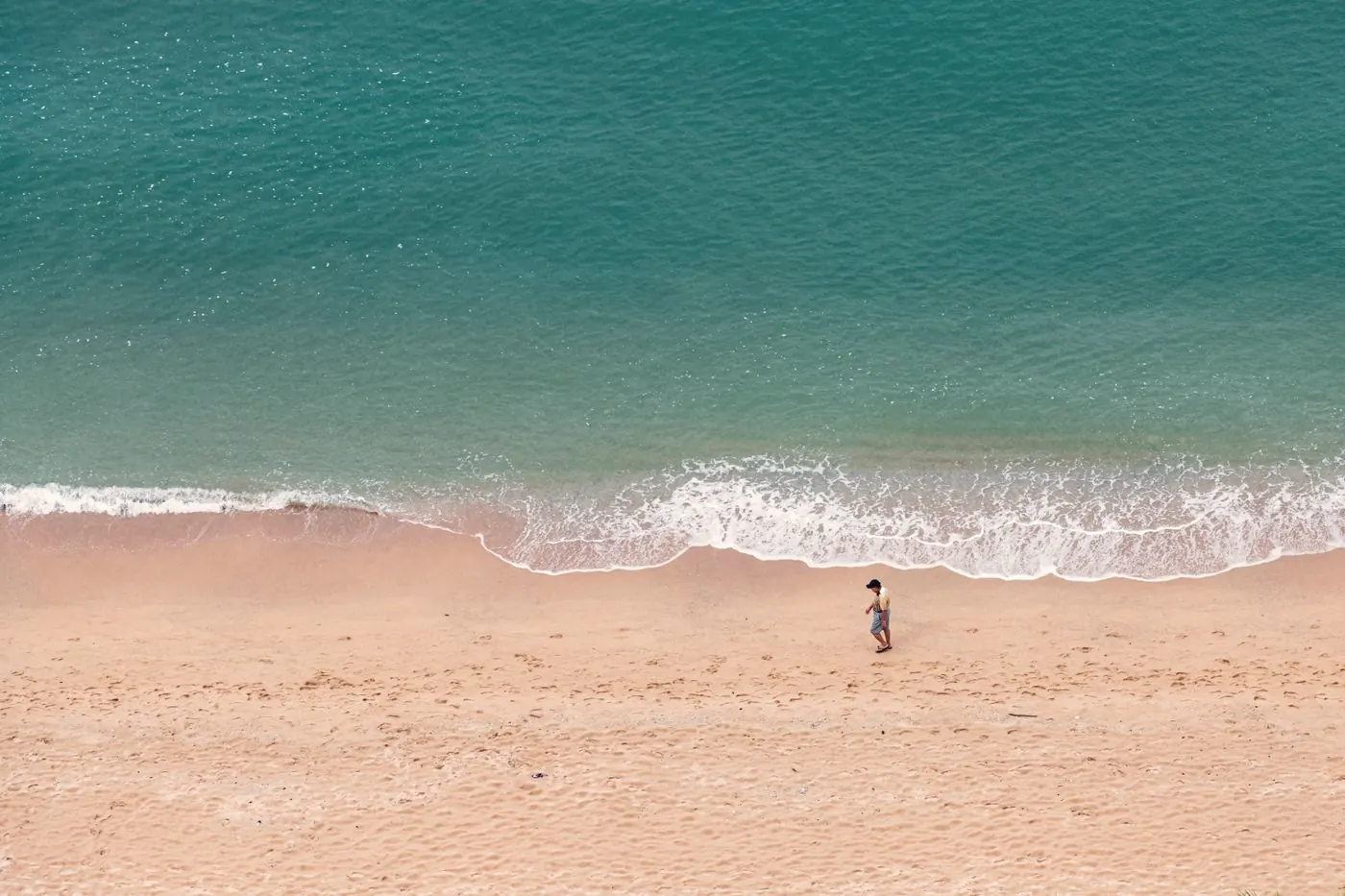 Aerial view of a quiet stretch of Pattaya beach with turquoise water and pale sand