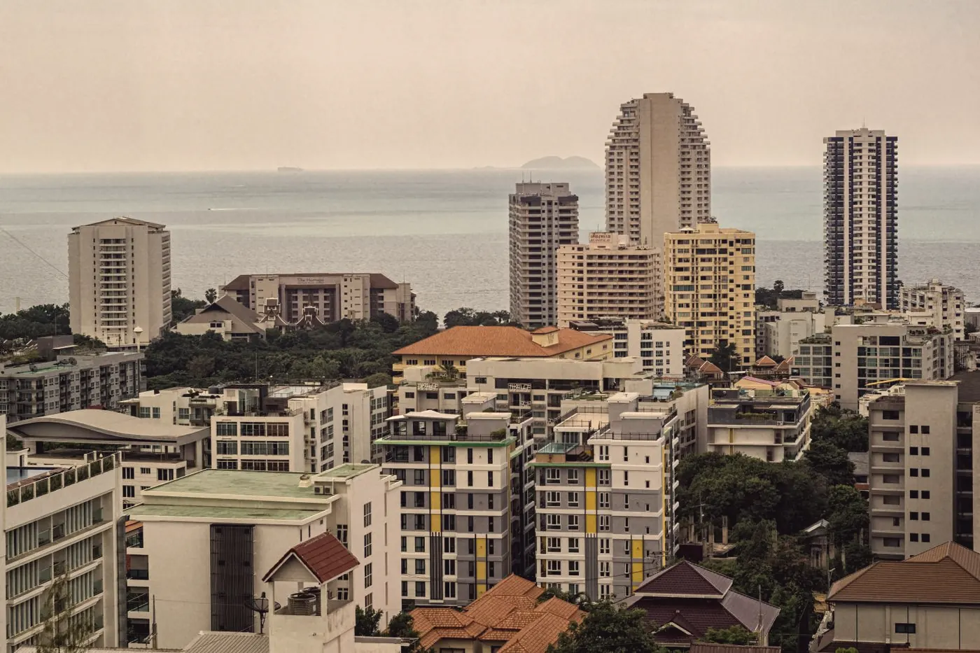 High-rise buildings on a green hillside overlooking the sea in Pattaya, Thailand