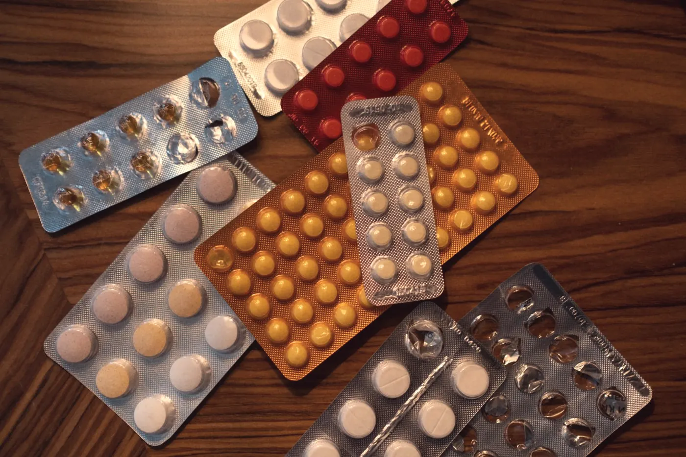 Blister packs of tablets on a wooden table, like a 28-day PEP course