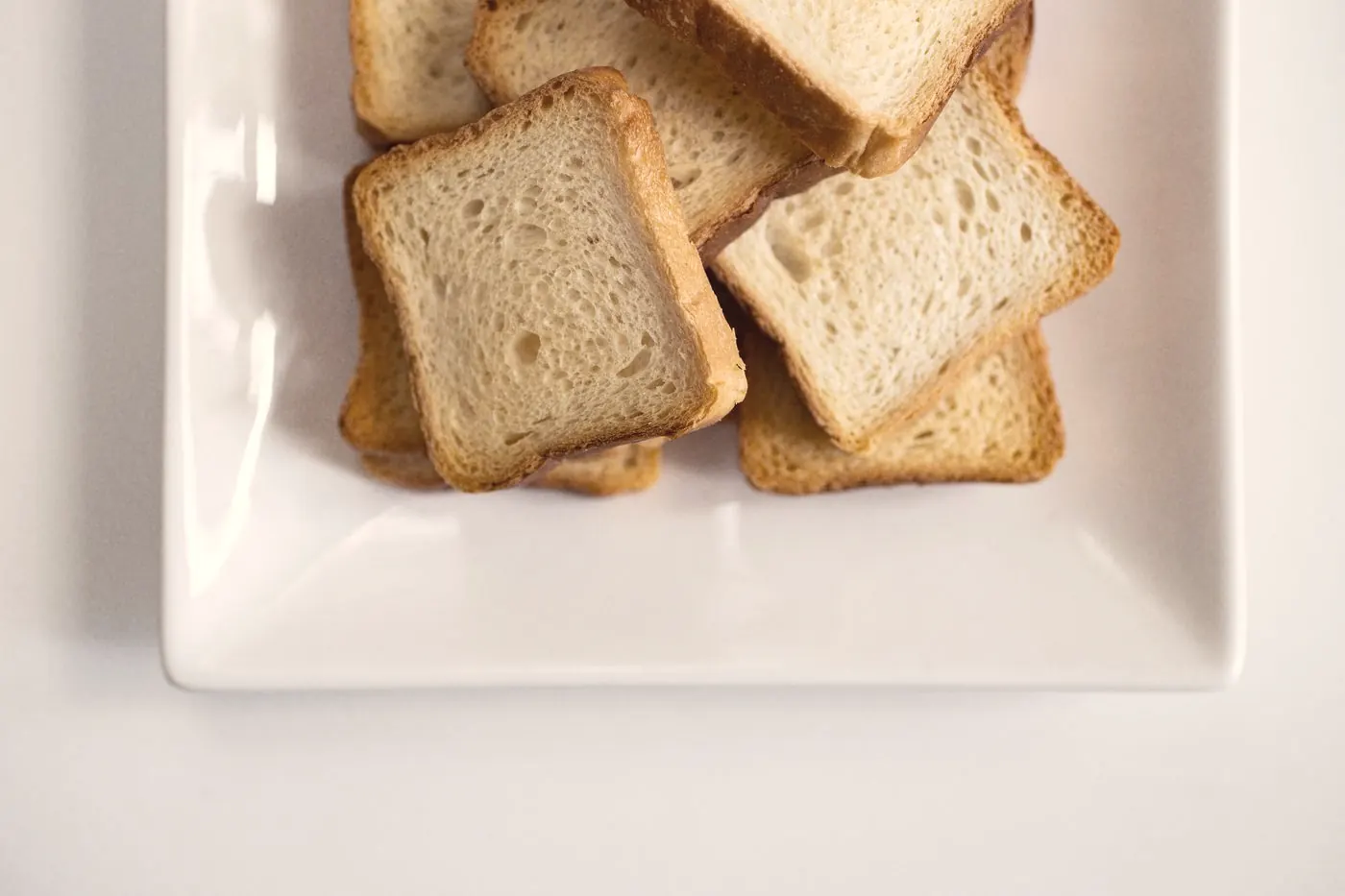 Slices of plain toast on a white plate, a light snack to take with a PEP dose