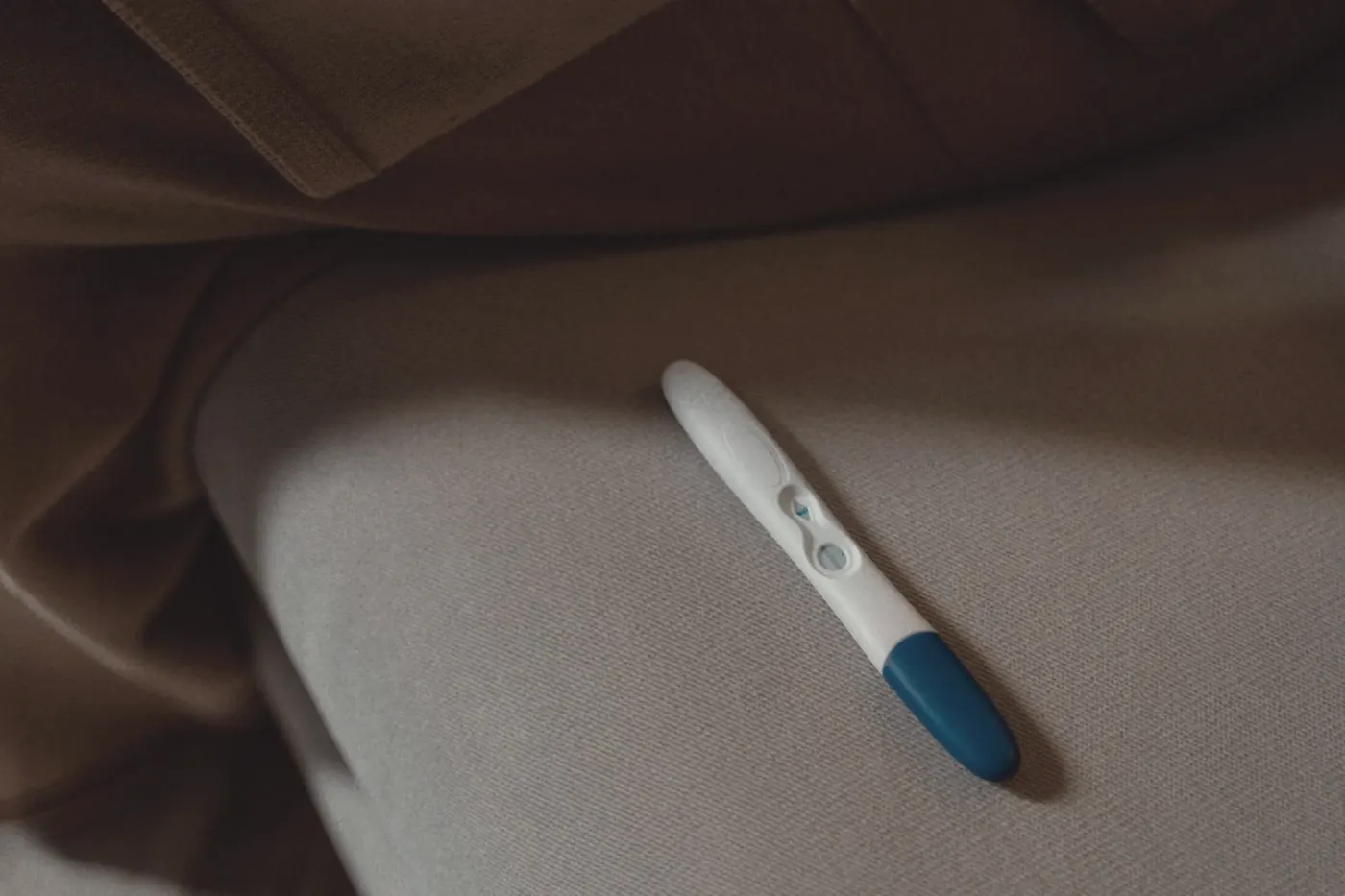 A home pregnancy test resting on soft fabric, part of planning PrEP around pregnancy