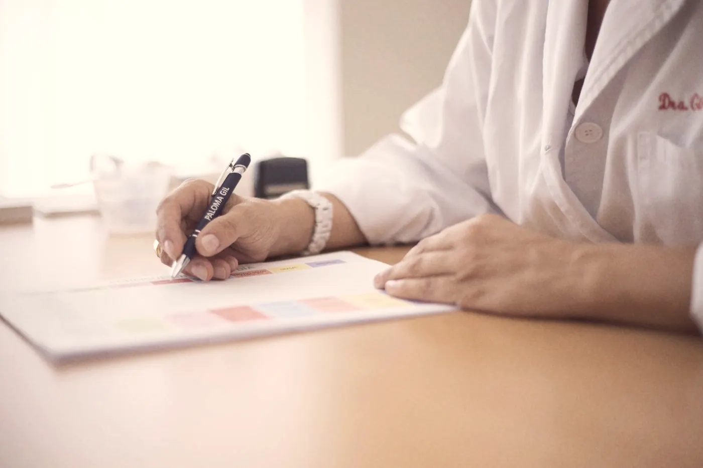 A doctor writing a PrEP prescription at a clinic desk