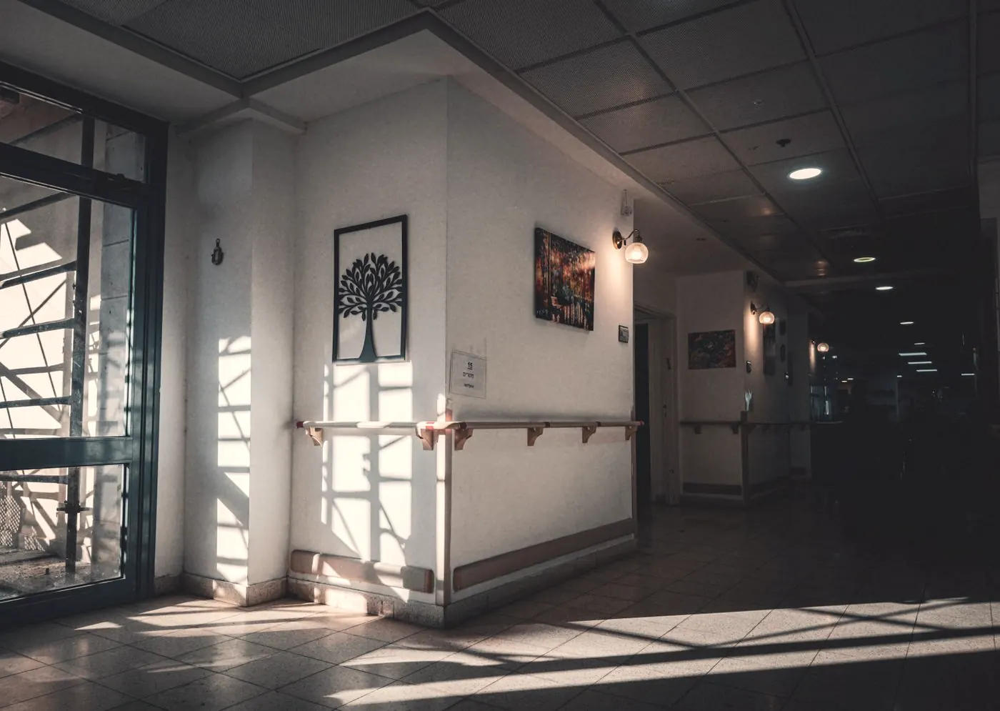 A quiet public hospital corridor with sunlight coming through the windows