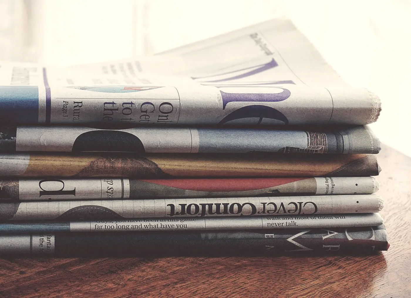 A stack of folded newspapers on a wooden table, standing for scary HIV headlines