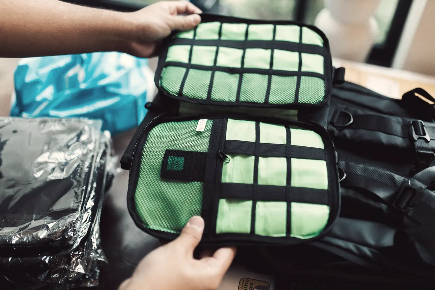 Hands holding an open travel organiser pouch while packing hand luggage